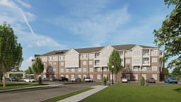Four-story apartment building with parking and trees