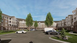 Modern apartment complex with parking lot and trees