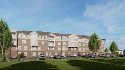 Four-story apartment building with parking lot and trees