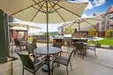 Outdoor patio with tables, umbrellas, and grill