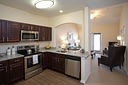 Modern kitchen with granite counters and living area