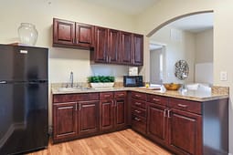 Modern kitchen with dark wood cabinets and granite counters