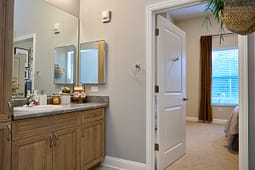 Modern bathroom vanity with open door to bedroom