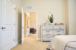Beige bedroom with dresser and open door