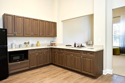 Modern kitchenette with wooden cabinets and beige countertops