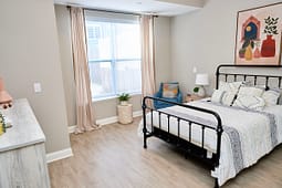 Modern bedroom with black metal bed and large window