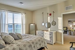 Bright bedroom with dresser and round mirrors