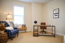 Cozy home office with desk and plaid armchair