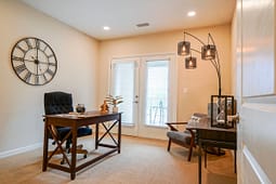 Modern home office with wooden desk and clock