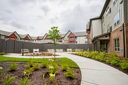 Landscaped apartment courtyard with benches and walkway