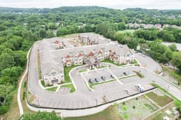 Aerial view of large apartment complex surrounded by trees