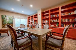Cozy library room with table and bookshelves