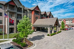 Modern apartment complex with covered entrance and flags