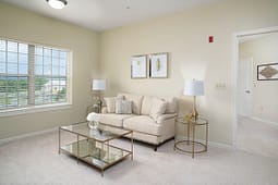 Bright beige living room with sofa and glass table