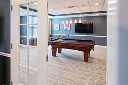 Modern game room with pool table and TV