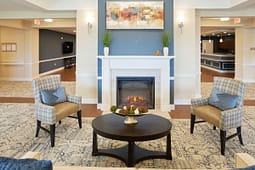 Cozy lobby seating area with fireplace and armchairs
