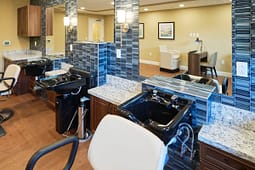 Modern salon with black shampoo sinks and mirrors