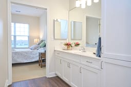Bright modern bathroom vanity leading to bedroom