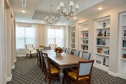 Elegant dining room with long table and bookshelves