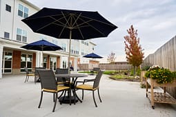 Outdoor patio with tables, umbrellas, and garden