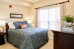 Cozy bedroom with blue patterned bedspread and window