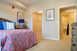 Bright bedroom with floral bedspread and open closet
