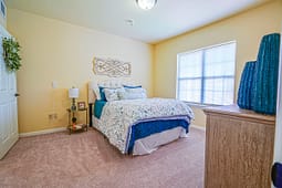 Bright bedroom with blue bedding and beige walls