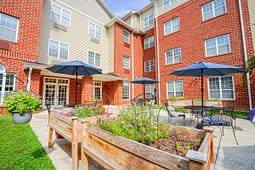 Apartment courtyard with patio seating and flower beds