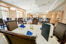 Elegant dining room with tables set and blue napkins