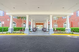 Covered entrance with white columns and rocking chairs