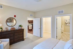 Bright bedroom with dresser, closet, and ensuite bathroom