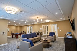 Modern lounge with sofas, pool table, and TV