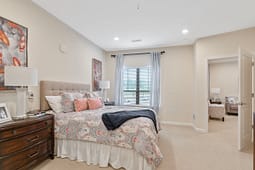 Bright staged bedroom with patterned bedding and window