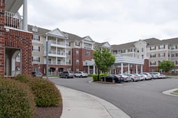 Multi-story apartment building with covered entrance and parking