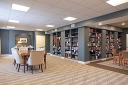 Cozy library reading room with bookshelves and tables