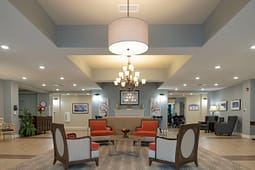 Elegant senior living lobby with chandelier and seating area