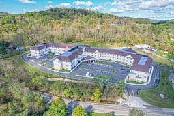 Aerial view of large residential complex in wooded area