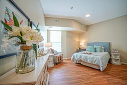 Bright modern bedroom with wooden floors and blue accents