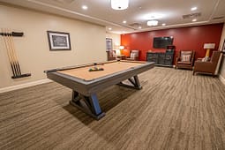 Modern game room with pool table and seating