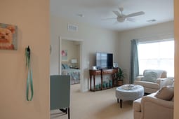 Bright living room with TV and armchairs