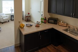 Modern kitchenette with dark cabinets and countertop appliances
