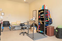 Physical therapy room with parallel bars and weights