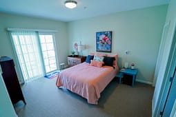 Bright bedroom with pink bed and floral artwork