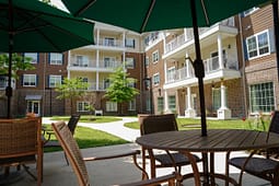Apartment courtyard with patio tables and green umbrellas