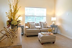 Cozy beige living room with loveseat and ottoman