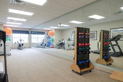 Modern fitness room with mirrors and dumbbells