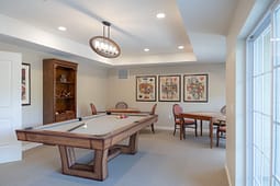 Modern game room with pool table and card tables