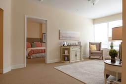 Bright neutral living room with adjacent bedroom view