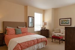 Cozy bedroom with orange bedding and armchair