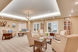 Spacious beige lounge with armchairs and wooden tables